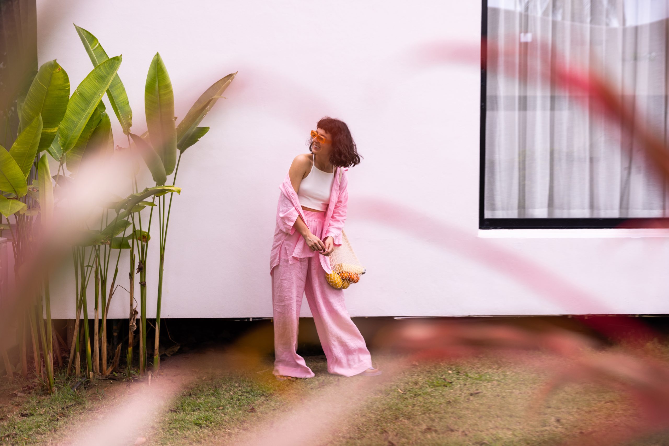 beautiful young caucasian brunette girl summer clothes laughs while standing outdoors near white house lifestyle concept scaled